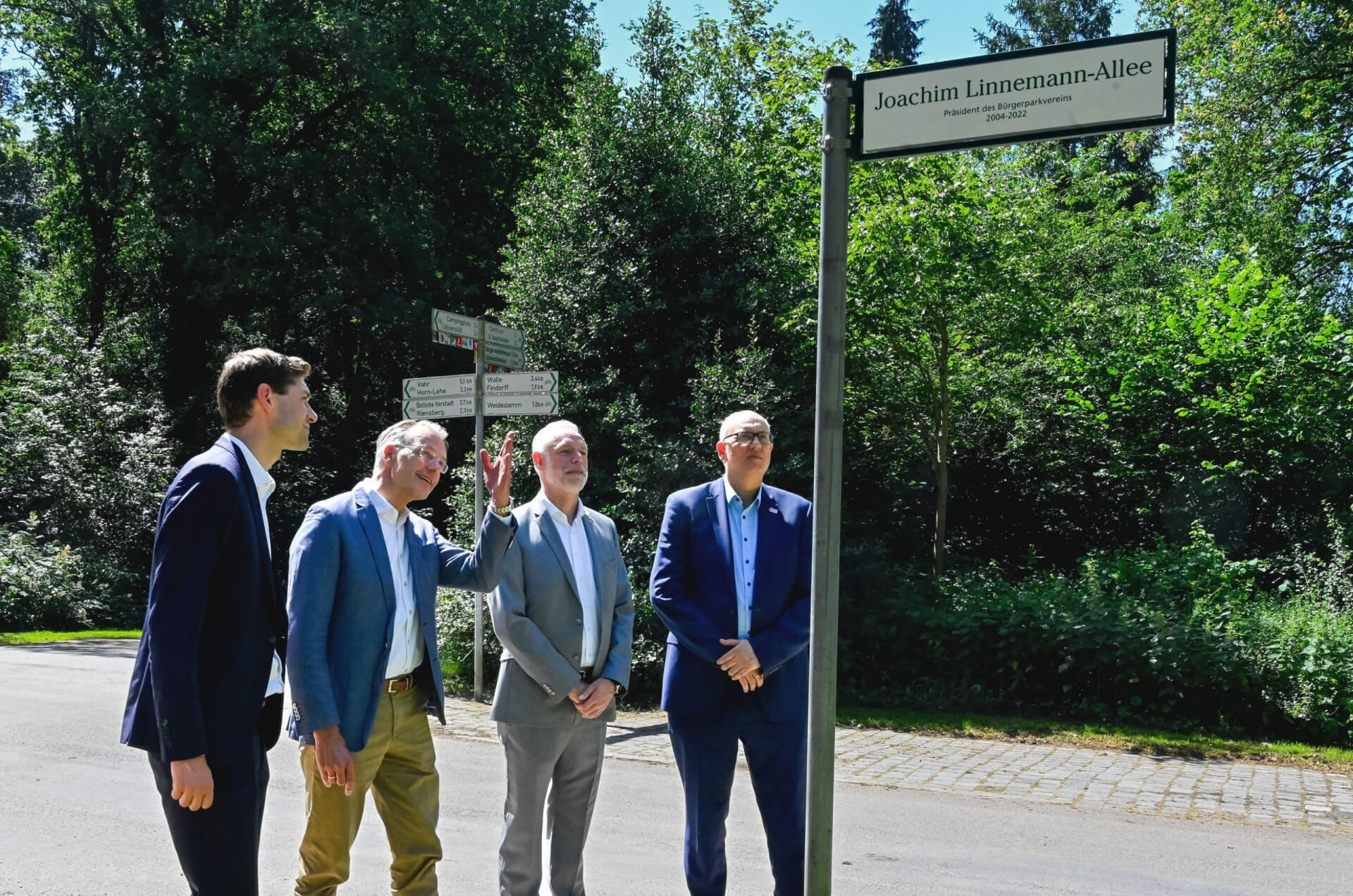 Foto: v.l.n.r.: Marcel Linnemann (Justus Grosse), Bürgerparkpräsident Prof. Dr. Dietrich Grashoff, Bürgerpark-Direktor Tim Großmann und Bürgermeister Andreas Bovenschulte am neuen Straßenschild (© Senatspressestelle)